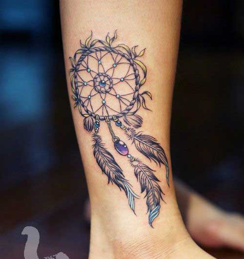 Multicoloured dream catcher and feather on the leg
