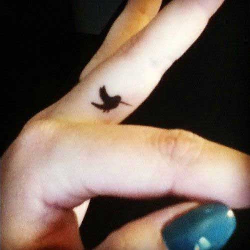 Small and cute black colourful humming bird on finger