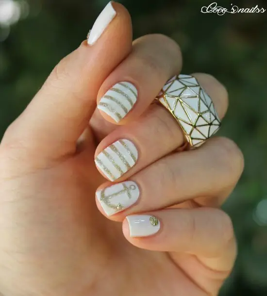 long nails painted in light pink base with a diamond-shaped glitter tip and anchors creating the tips
