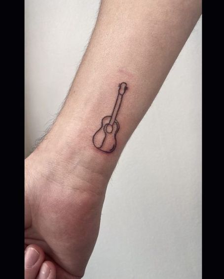 Guitar Outline Tattoo On A Wrist