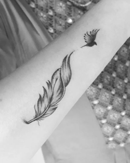 Feather Tattoo With The Tiny Bird On The Wrist