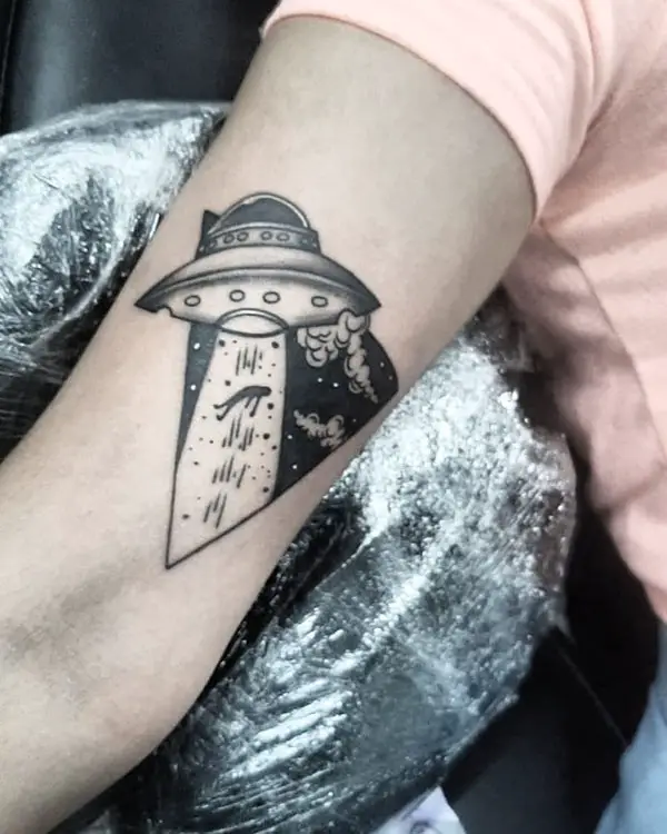 UFO tattoo taking in a human