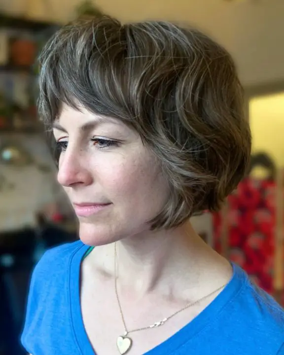 Voluminous shags with feathered bangs haircut For Women Over 50