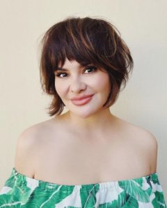 Woman with layered haircut adding volume to postpartum thinning hair