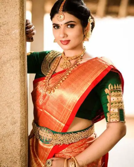 Red Silk Saree With Green Colored Blouse With Temple Design On Sleeves