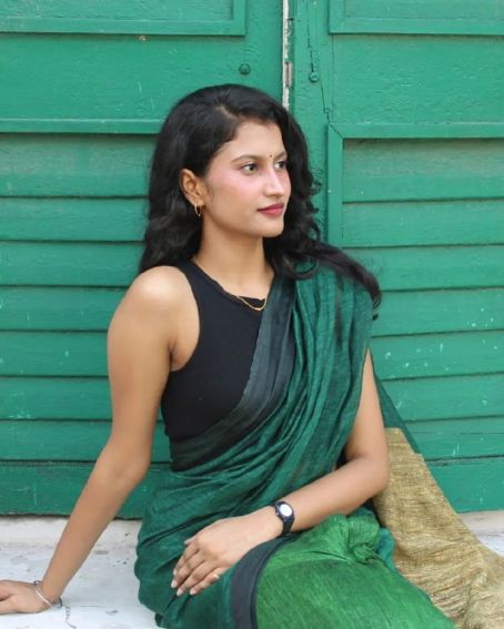 Black Sleeveless Blouse With A Green Saree