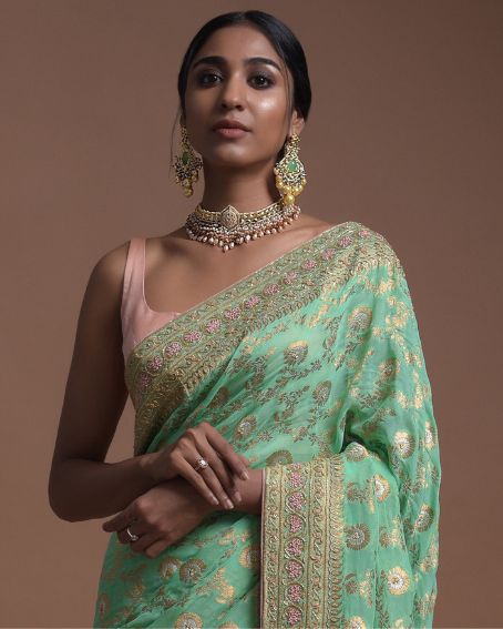 Kundan Work Green Banarasi Saree with Peach Sleeveless Blouse